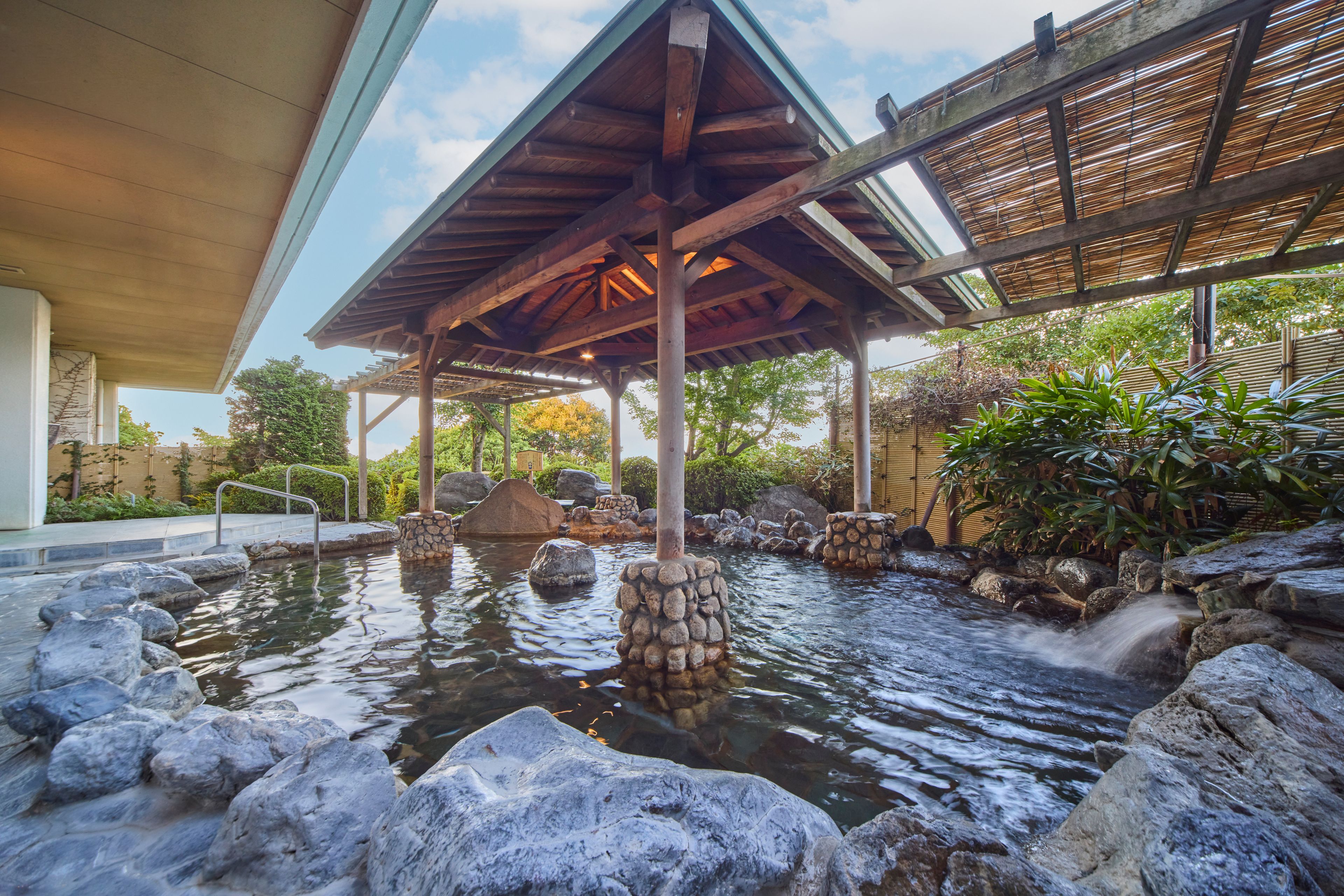 A covered outdoor area with a water feature surrounded by rocks and plants.