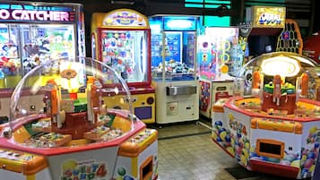 A row of brightly lit arcade games with various colorful displays and prizes inside.