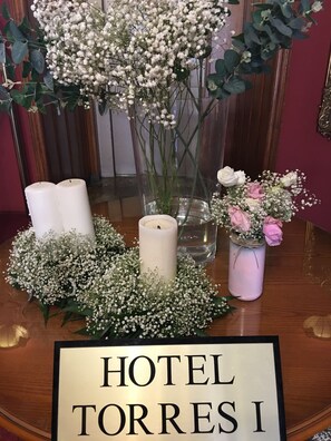 Pöydällä on kynttilöitä, kukkia ja kyltti, jossa lukee: ”HOTEL TORRES I”.
