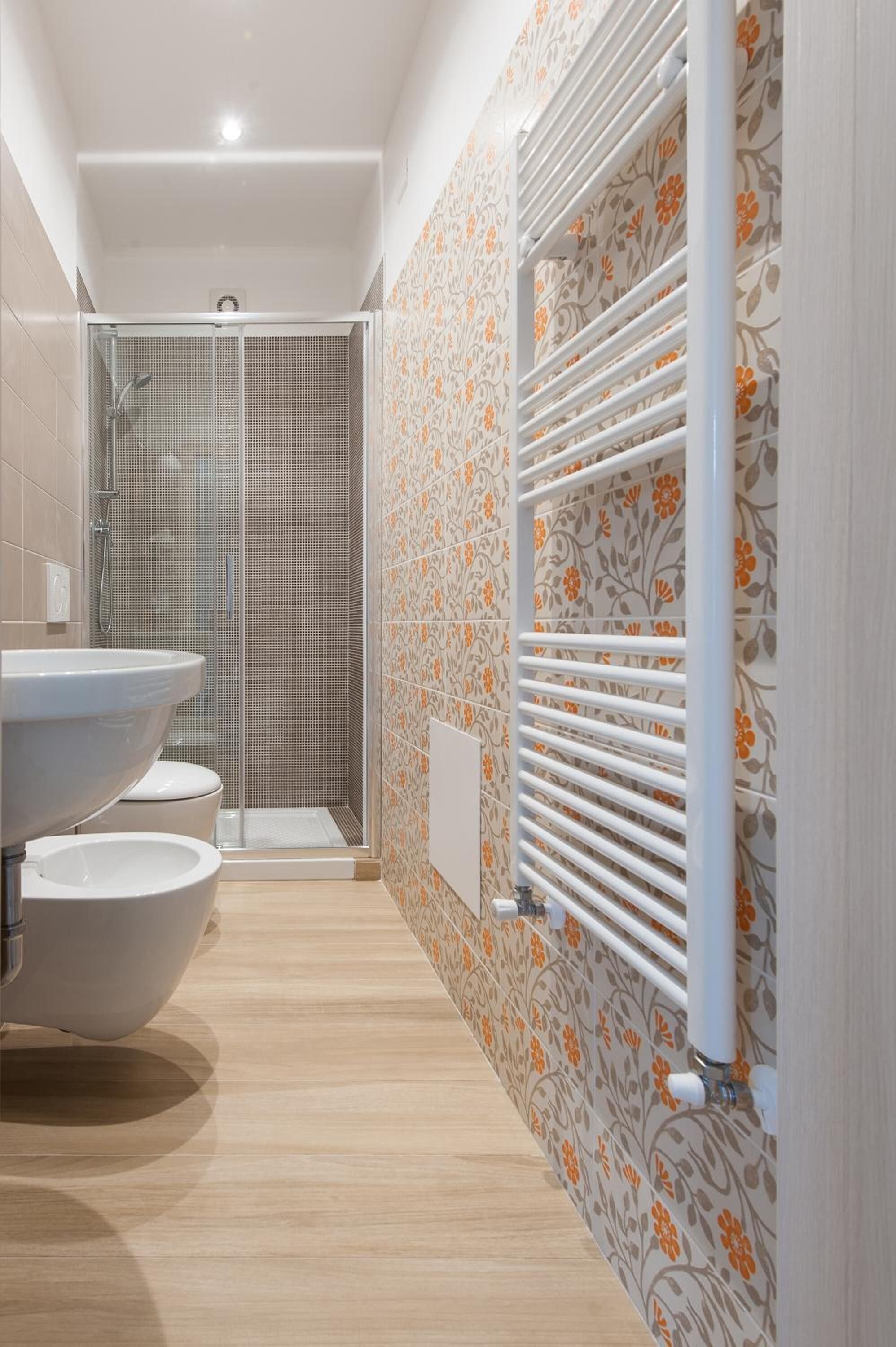 A bathroom with a large sink, toilet, and shower.
