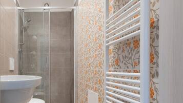 A bathroom with a large sink, toilet, and shower.