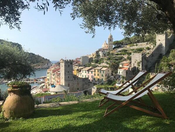 A coastal town with historic buildings, a prominent tower, and a view of the sea.