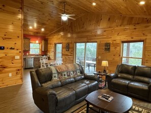 A log cabin interior with a living room, a dining area, and a kitchen. - Charming cabin with an Amazing view! - pet and motorcycle friendly! 2 Bedroom Cabin by RedAwning (Tellico Plains)