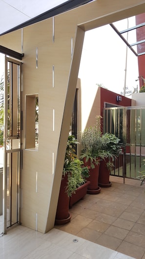 Un bâtiment moderne au design angulaire original, doté d’une entrée en verre et agrémenté de plantes en pot.