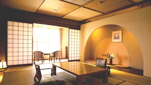 A traditional Japanese room with tatami flooring, a low table, and shoji screens. - Hamanako Kanzanjionsen Hotel Kikusuitei (Hamamatsu)
