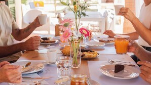 A breakfast setting with a table set for four people, featuring plates with food, drinks, and a vase with flowers. - Agriturismo La Quercia - Wine&Pool (Scansano)