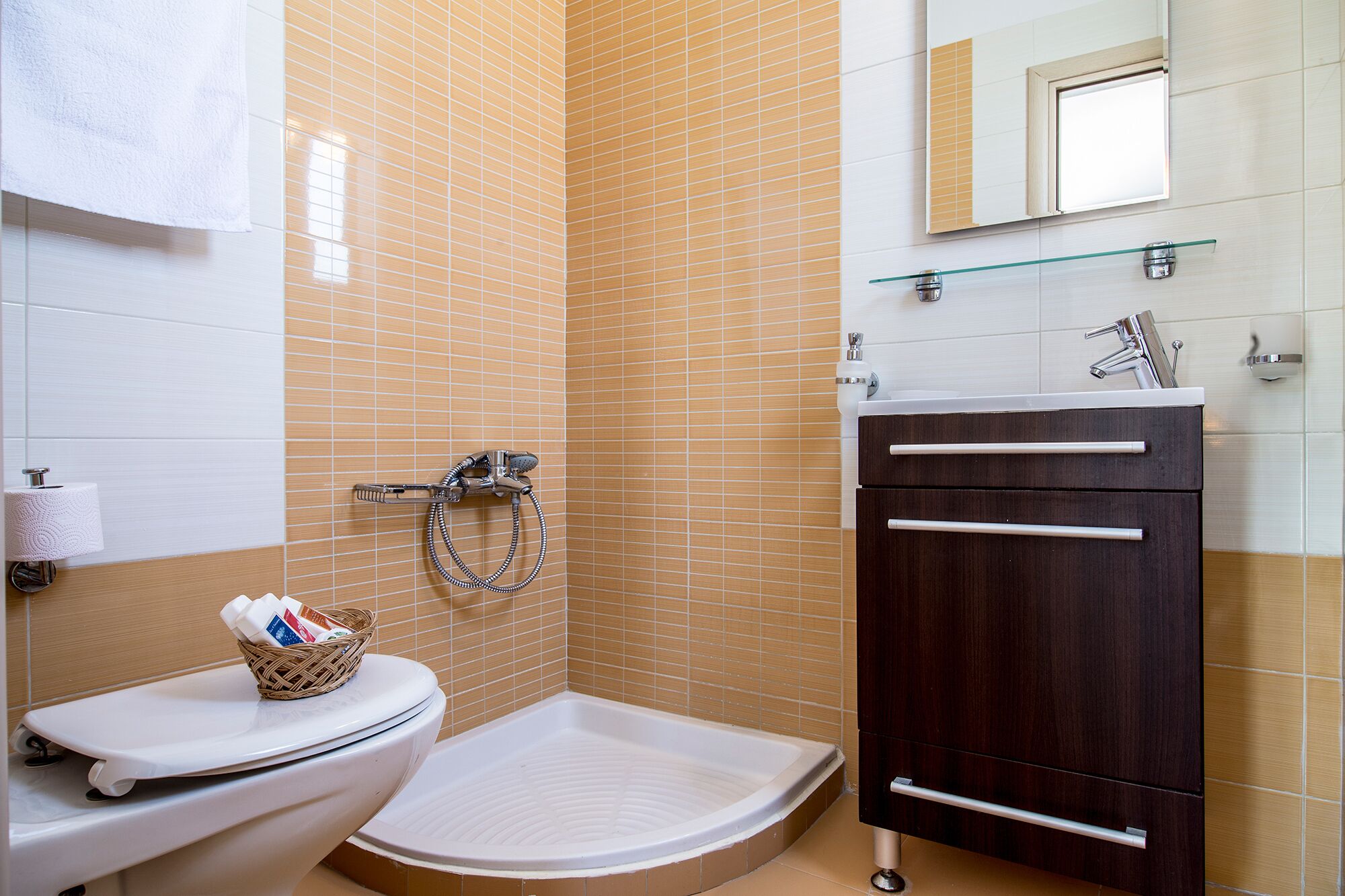 Un bagno con un water, un bidet e un piccolo lavandino con uno specchio sopra.