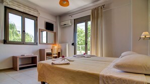 A hotel room with a large bed, a desk, a chair, and a TV. - Villa retreat in the heart of Cretan nature (Rethimno)