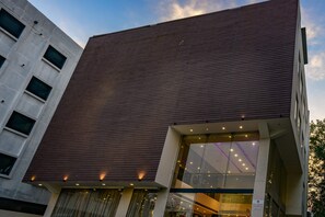 A modern building with a flat roof, large windows, and a glass entrance. - Hotel Veronica (Vadodara)