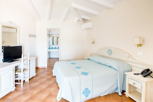 A bedroom with a bed, a desk, a television, and a telephone. - Marina Torre Navarrese Resort (Lotzorai)