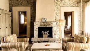 A cozy living room with a stone fireplace, striped sofas, and a coffee table. - CASA DARIO APARTMENT 5 (Castellina in Chianti (SI), Italia)