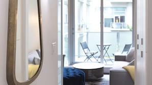 A narrow hallway with a large mirror, leading to a balcony with a table and chairs. - Hudson Hideaway-Historic Hudson Building in Beautiful Downtown Victoria by Victoria Prime! (Victoria)