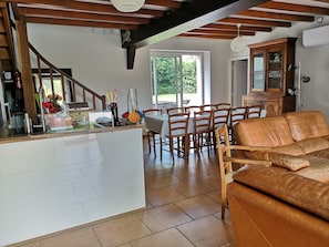 Une cuisine avec un îlot central, des chaises en bois, un canapé en cuir marron et une table à manger.