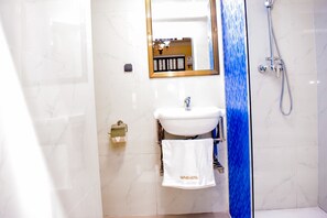 Chambre Deluxe | Salle de bain | Douche, douche cascade, savon, papier de toilette