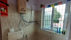 A small bathroom with a toilet, sink, shower, and a window with a view. - A Dutch Nepali home with a beautiful view (kathmandu)