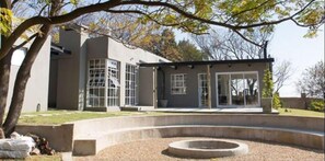 A modern building with large windows and a circular outdoor seating area.
