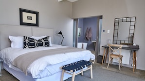 Ein modernes Schlafzimmer mit einem großen Bett, einem Schreibtisch und einem Stuhl.