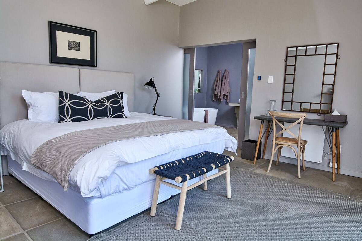 Un dormitorio moderno con una cama grande, un escritorio y una silla.