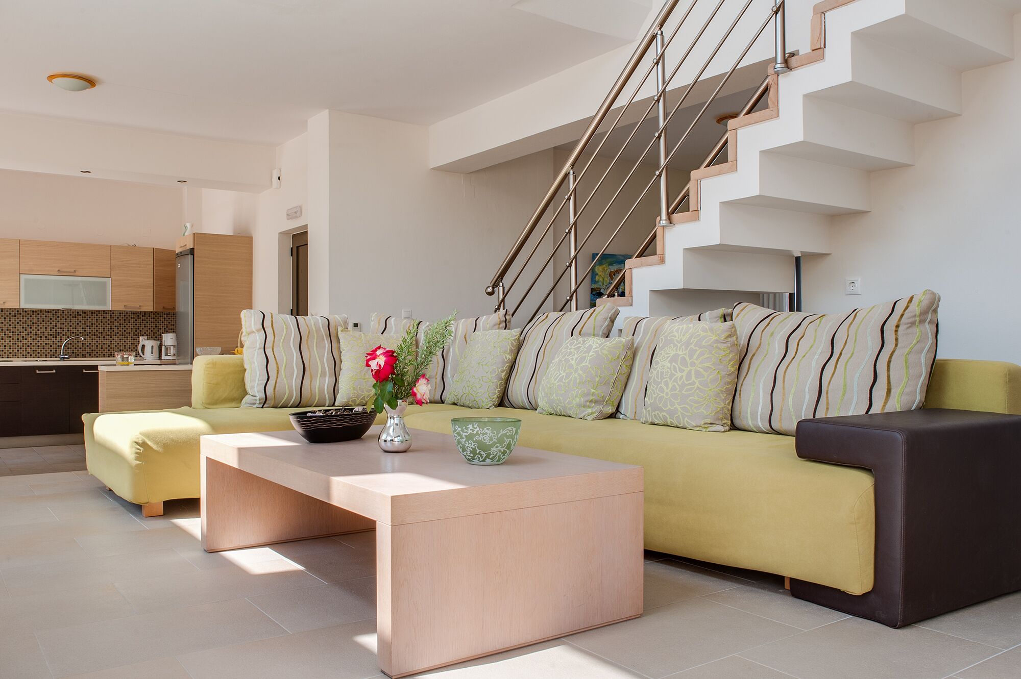 Un salon moderne avec un canapé, une table basse et un escalier.