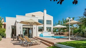 A modern house with a pool, outdoor seating, and umbrellas. - Countryside villa with private pool and views (Rethimno)