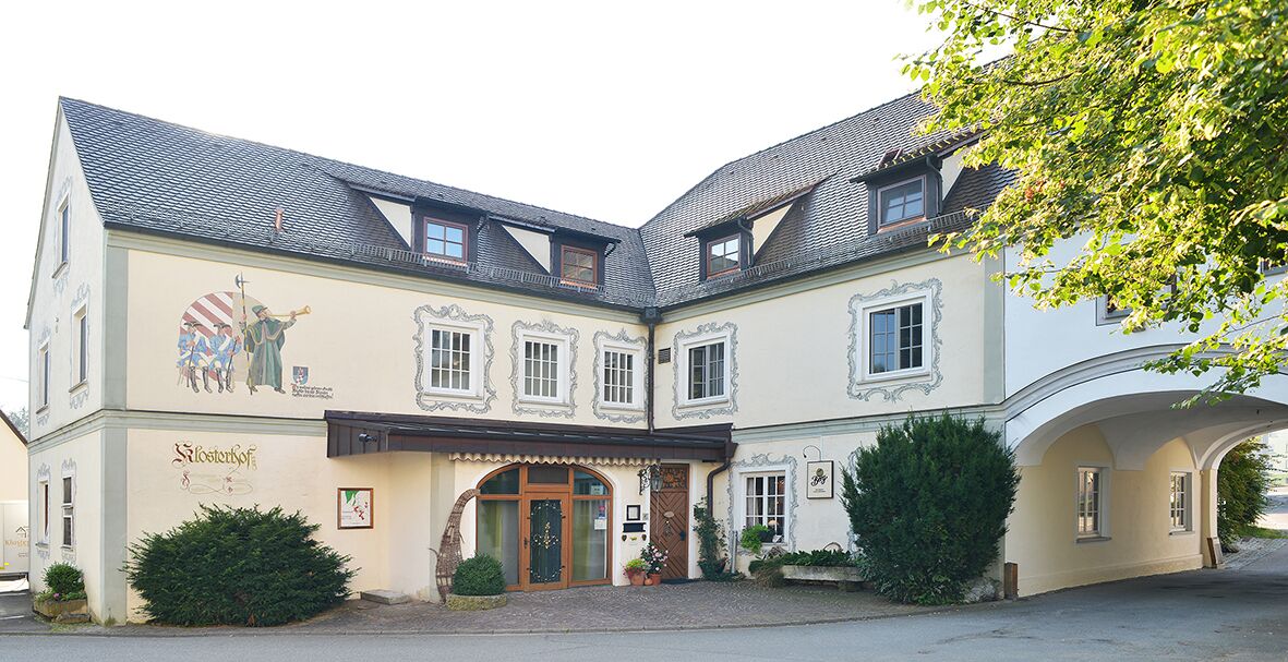 Un bâtiment de style architectural traditionnel, doté d’une entrée centrale surmontée d’un arc décoratif, de nombreuses fenêtres et d’une fresque représentant des personnages historiques.