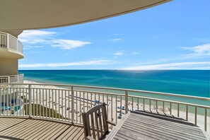 A balcony with a view of a beach and ocean.