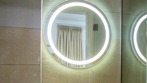 A bathroom with a circular mirror and a lighted ring above it. - Bella Residencia (Lekki)