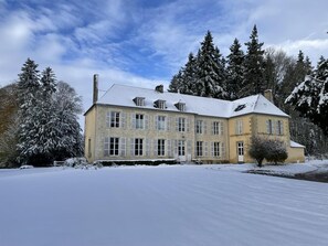 A large, two-story building with a symmetrical facade, multiple windows with shutters, and a snow-covered roof. - Experience Castle Charm with WiFi in Bellavilliers (Bellavilliers)