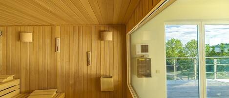 A sauna with wooden walls and benches, a glass door leading outside, and a small window.