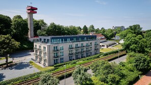 A modern building with multiple floors, balconies, and a prominent tower structure. - Hotel BeachSide (Eckernfoerde)