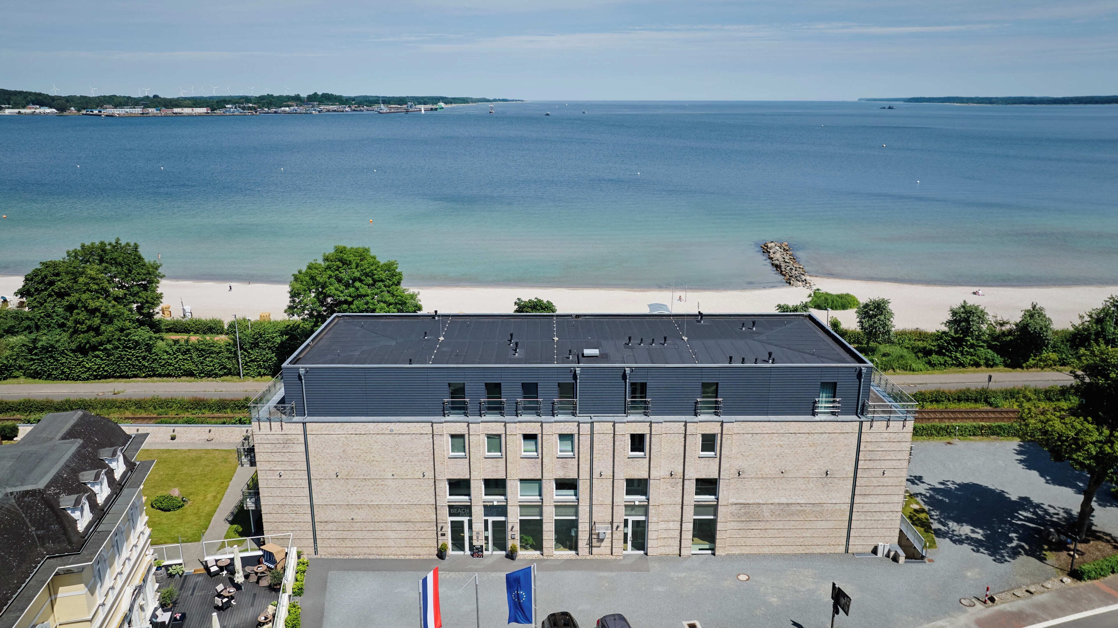Ein Gebäude mit flachem Dach, großen Fenstern und einer Flagge.