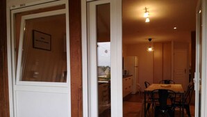 A compact kitchen with a dining area, a refrigerator, and a microwave.