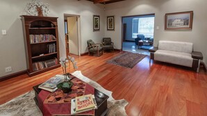 Un salón amplio con suelo de madera, una estantería, una mesa de centro y un sofá.