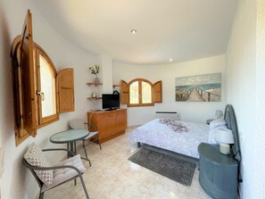 A bedroom with a bed, a TV, a desk, and a chair. - T-0819, Villa Sueños, beautiful villa with mediterranean garden (Alicante)