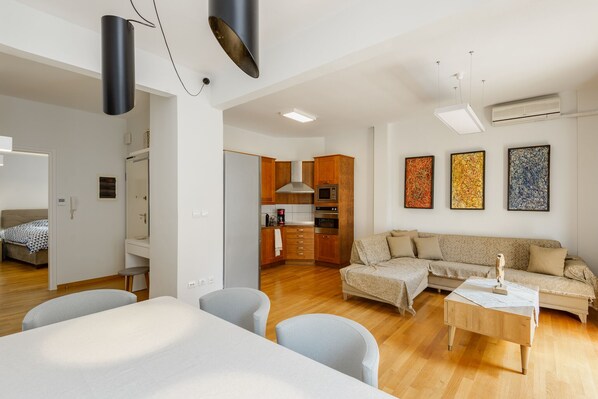 A modern apartment with a living room, kitchen, and a bedroom.