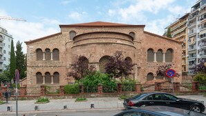 A historic building with a brick facade, arched windows, and a central dome.
