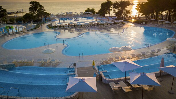 A large, multi-level swimming pool with sun loungers and umbrellas, surrounded by trees and overlooking the sea. - 3 * apartments / 5pax. (Zaton)