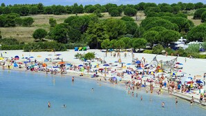 A beach with people swimming and sunbathing, umbrellas, and beach chairs. - 3 * apartments / 5pax. (Zaton)