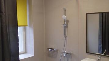 Een douche, handdoeken, zeep, toiletpapier