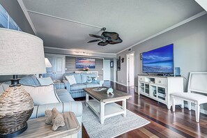 A modern living room with a sofa, coffee table, and television. - Resort Style, Heated Pool, Walk to Top Beach (Siesta Key)