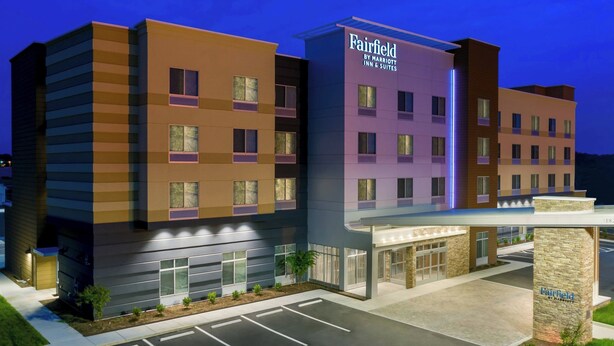 Ein mehrstödiges Hotel Fairfield by Marriott Inn & Suites mit modernem Design, das eine markante Eingangspartie und einen Parkplatz bietet.