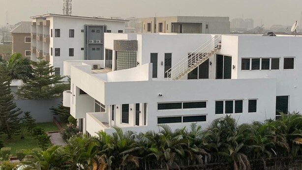 Un edificio moderno con varios pisos, una escalera y un techo plano.