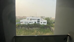 Vista desde una ventana con un edificio moderno al fondo.