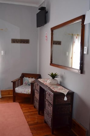 A room with a wooden bench, a mirror, and a small table with a plant. - Sondela Bed and Breakfast (Maletswai)