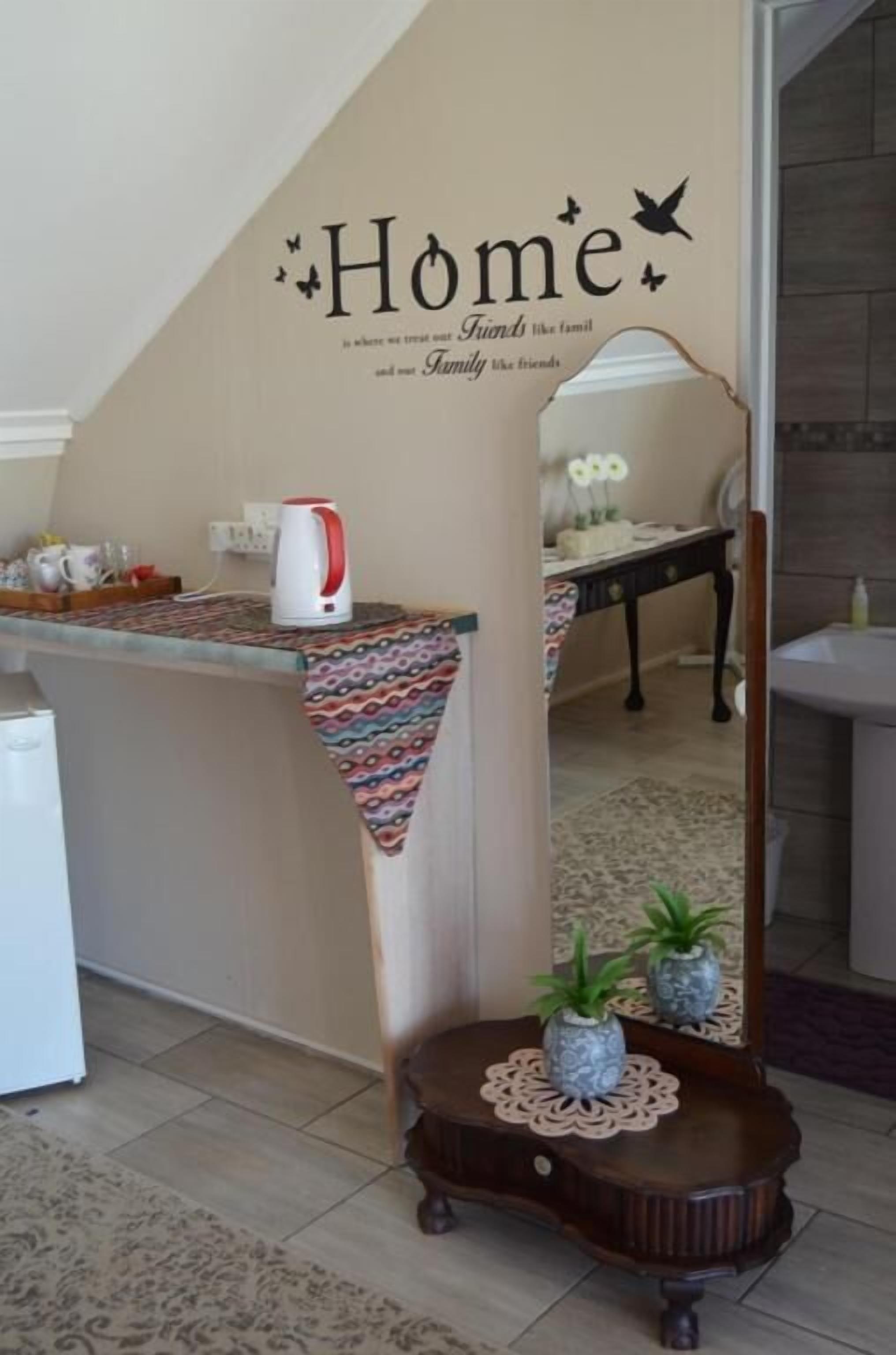Un interior de hogar con una encimera de cocina, una cafetera y un letrero decorativo en la pared.
