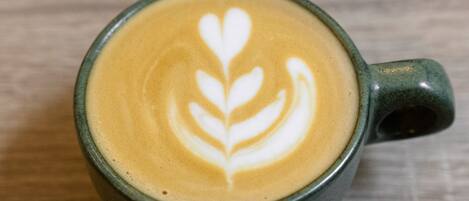 A cup of coffee with latte art on a wooden surface.