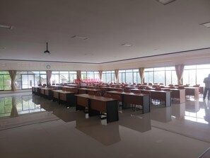 A spacious conference room with tables and chairs arranged for a meeting.
