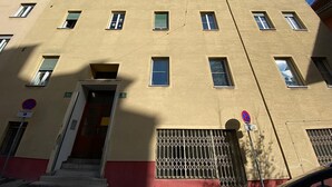 A multi-story building with a beige facade, multiple windows, and a visible entrance with steps. - Central Graz Apartments by Paymán Club (Graz)