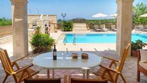 A pool area with a pergola, stone pillars, and outdoor seating. - Impressive four bedroom stone house with swimming pool (Rethimno)