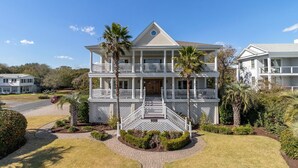 A two-story house with a front porch, a driveway, and a well-maintained lawn.